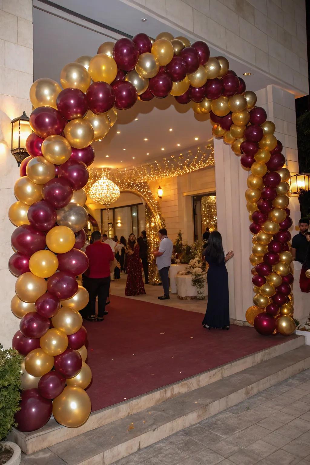 An exquisite balloon garland in claret and gold greets guests with unmatched elegance.