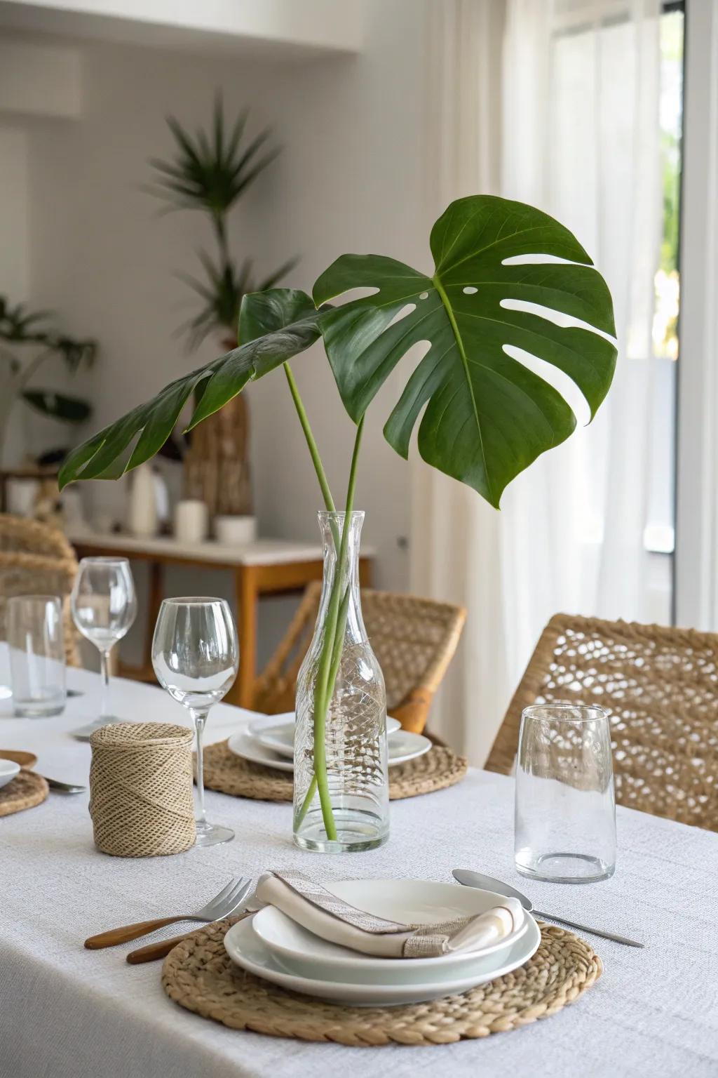 A see-through vase displaying a monstera leaf serves as a straightforward yet gorgeous centerpiece.