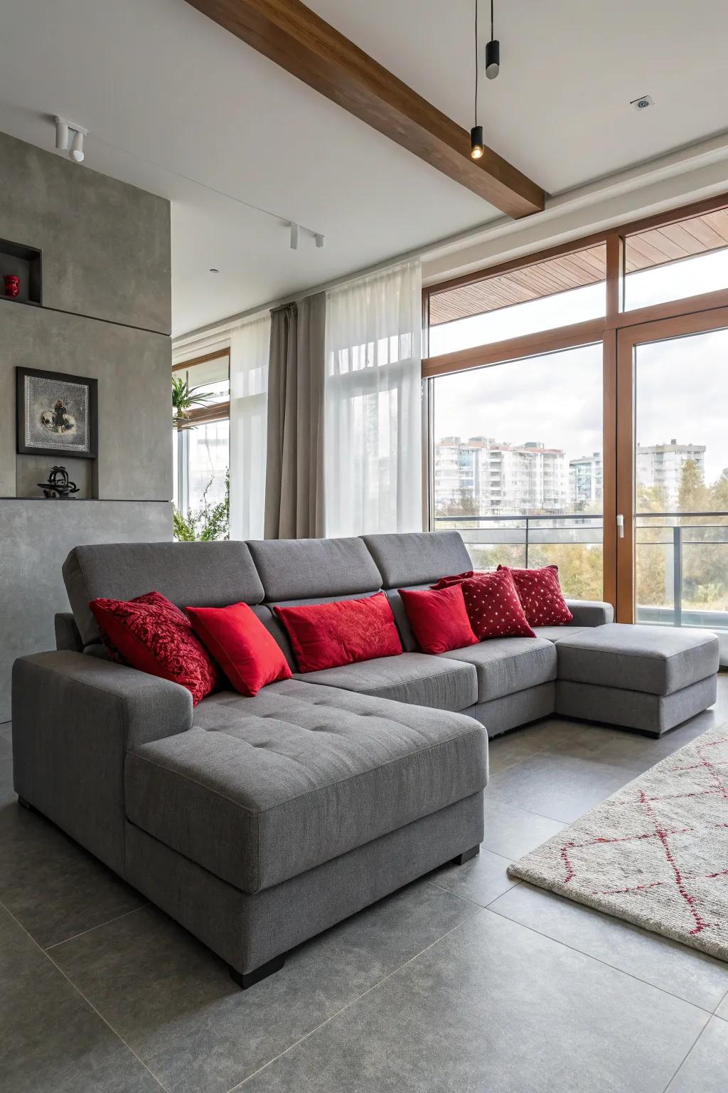 A welcoming living area showcasing a grey sectional and red cushions.