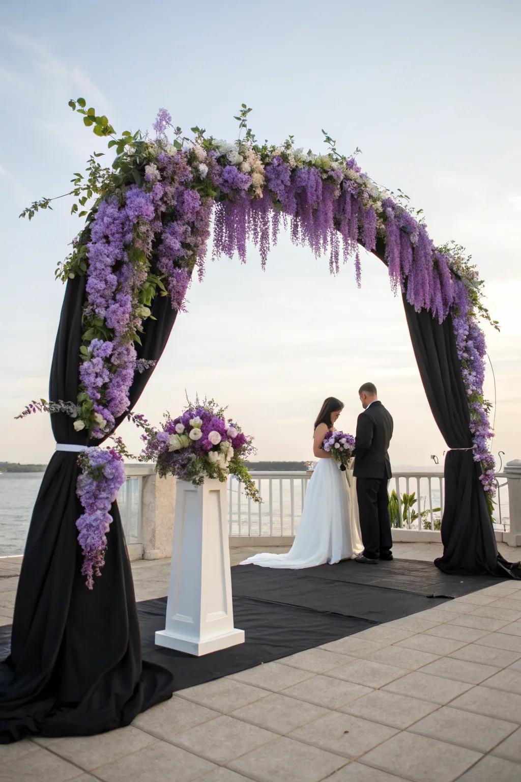 A captivating ceremony arch featuring violet wisteria and onyx hangings.