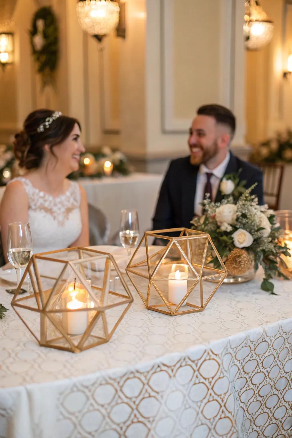 Geometric light stands are shown on the bride and groom's table.