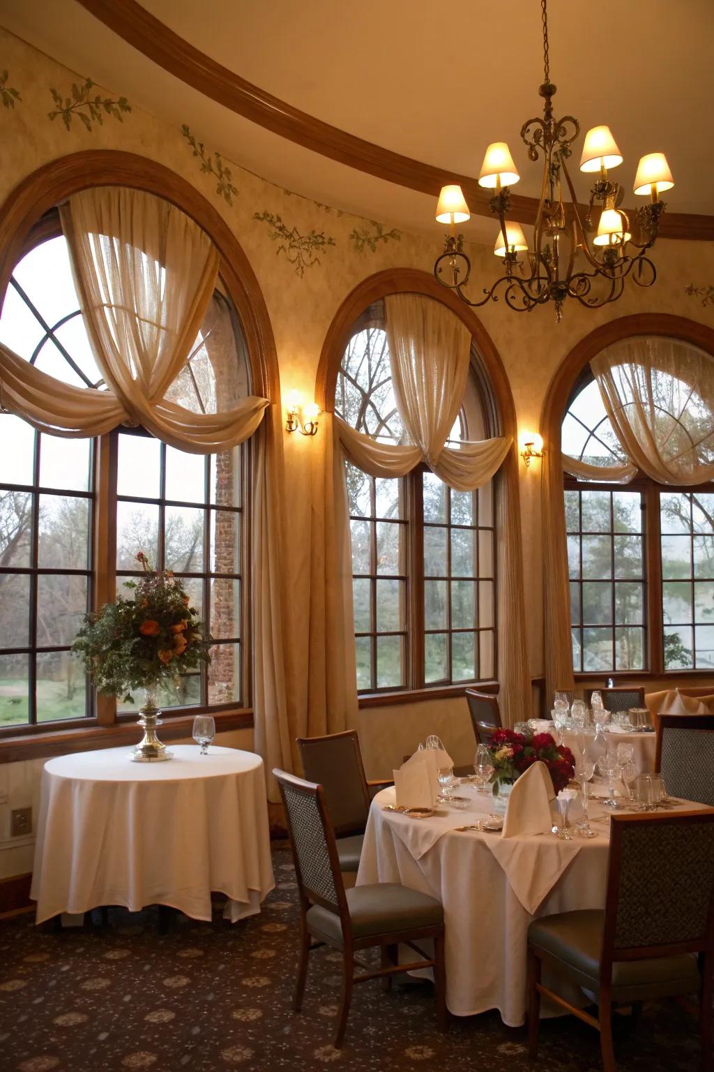 Romantic dining room featuring draped textile accents on arched windows.