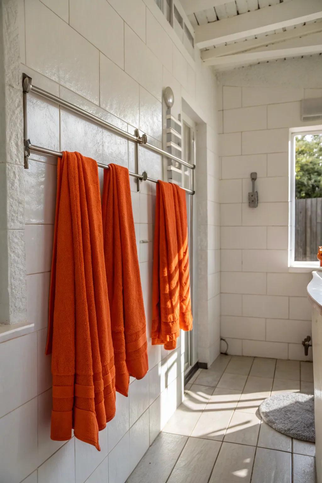 White bathroom showcasing vibrant orange towels for a pop of color.