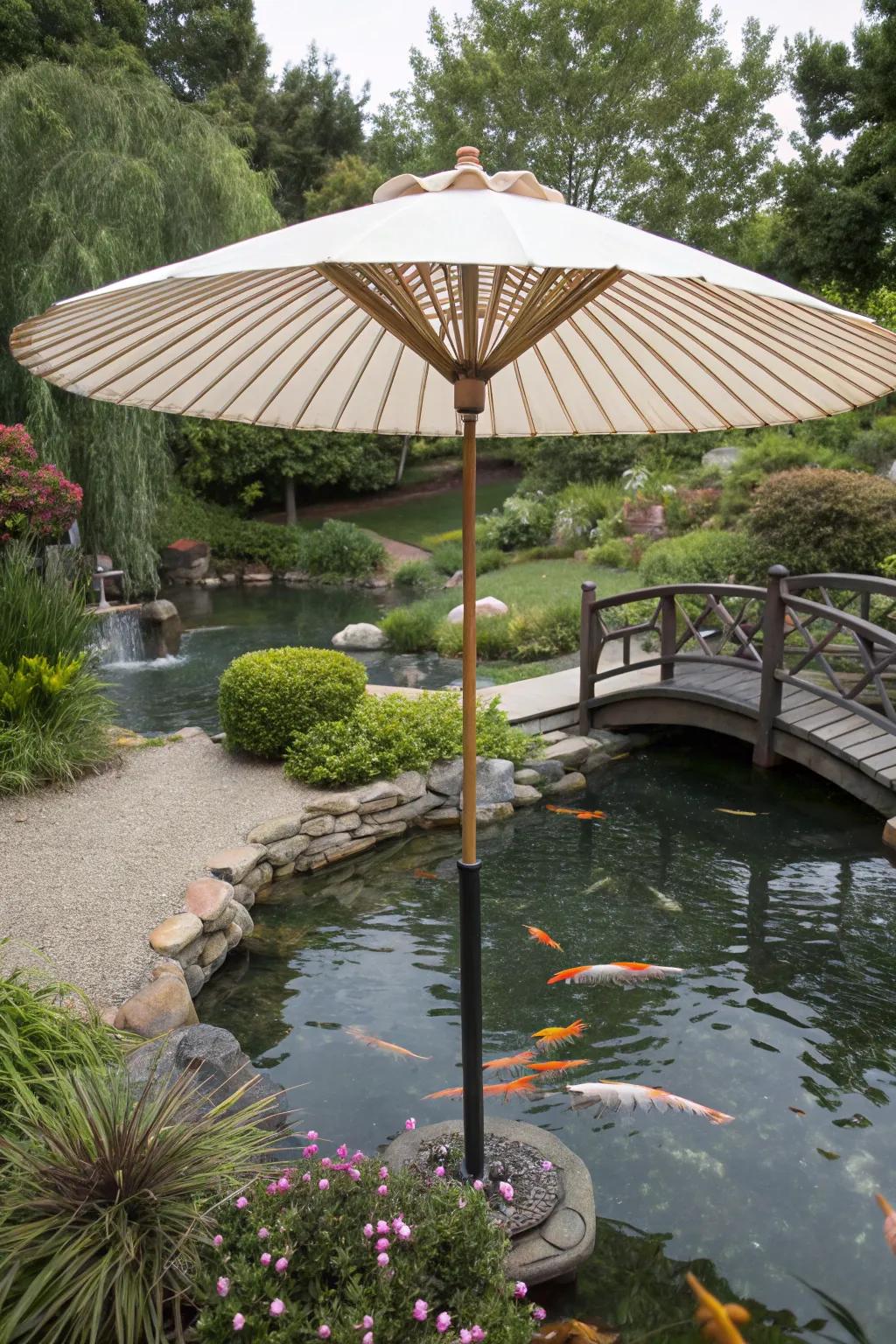 A sizable garden umbrella shields a koi pond from the sun.