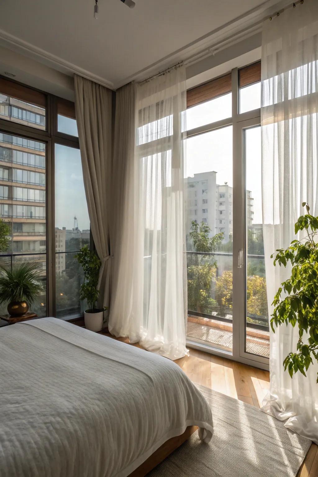 An apartment bedroom that has been designed to maximize natural light using sheer window coverings and large windows.