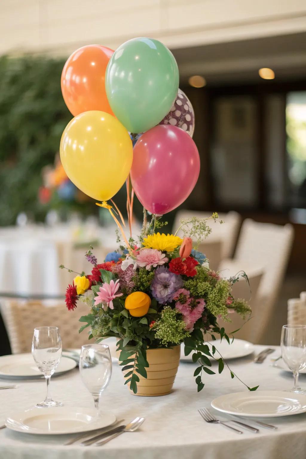 An energetic table centerpiece showcases a blend of balloons and blossoms for a charming impact.