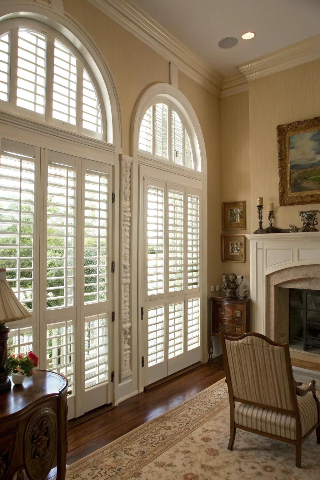Classic room setting featuring louvered panels on arched windows.