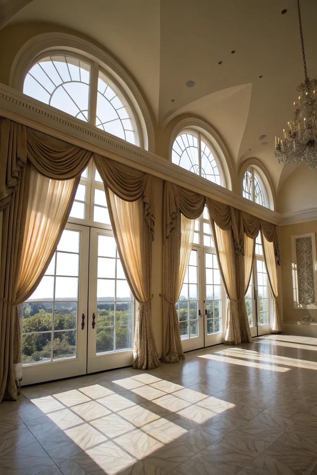 Grand living space enhanced with high-mount drape designs on arched windows.