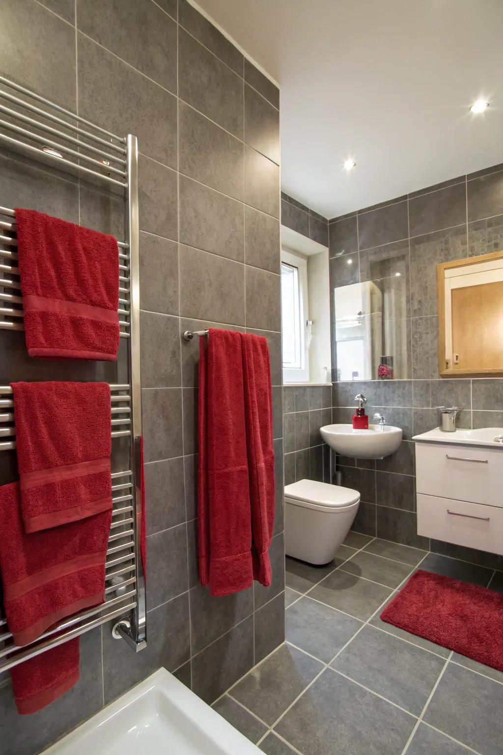 A bath space featuring grey tiles accented by a splash of red.