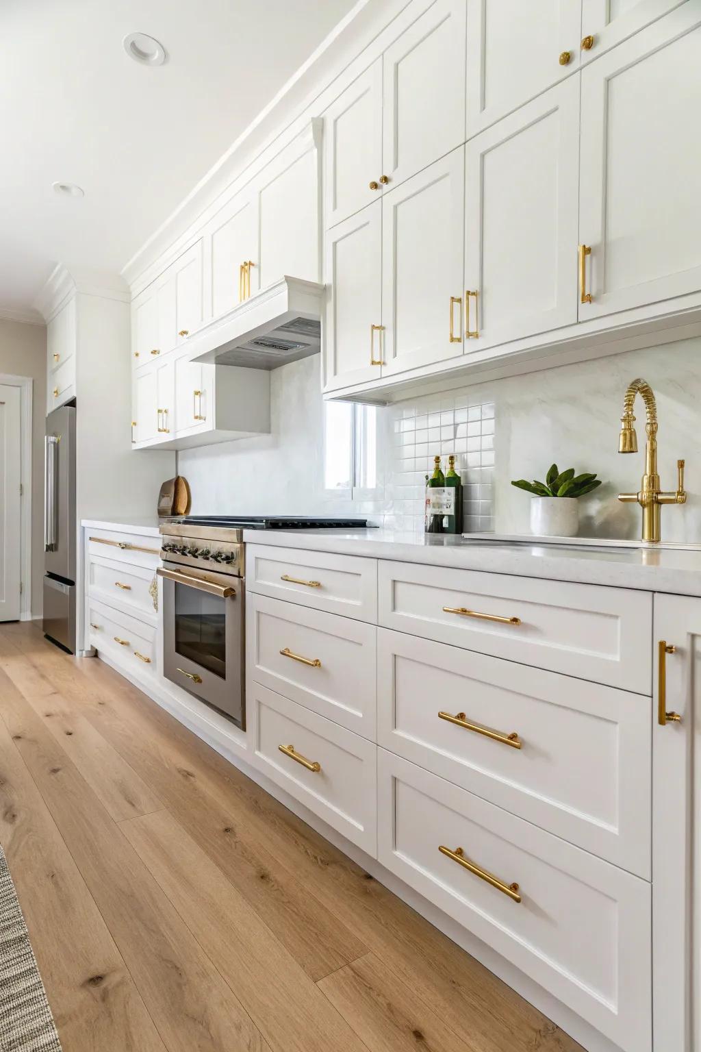 Luxurious gold accents elevating a white kitchen's elegance.